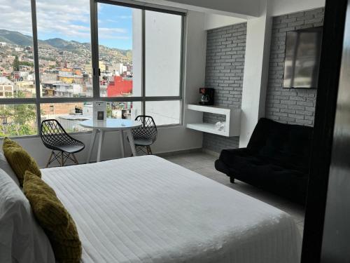 a bedroom with a bed and a view of a city at Hotel Daba Suites in Chilpancingo de los Bravos