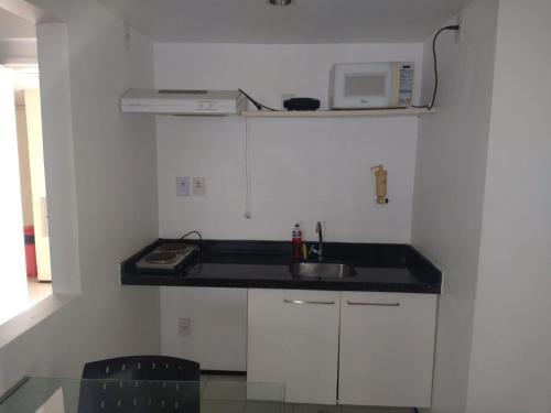 a small kitchen with a sink and a microwave at Apartamento Biarritz in São Luís
