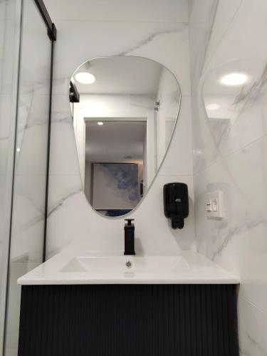 a bathroom with a sink and a mirror at Apartamentos Centro Oviedo Caveda in Oviedo