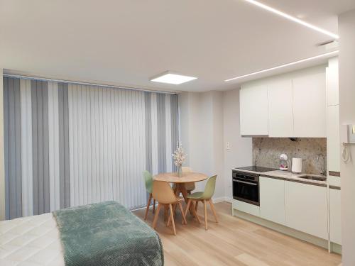 a bedroom with a bed and a table and chairs at Apartamentos Centro Oviedo Caveda in Oviedo