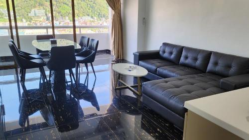 a living room with a couch and a table and chairs at PATONG TOWER FAMILY APARTMENT by PTA in Patong Beach