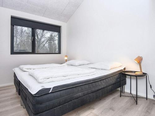 een groot bed in een kamer met een raam bij Holiday home Knebel LXII in Knebel