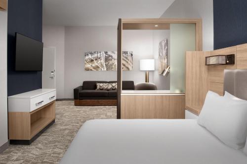 a bedroom with a bed and a living room at SpringHill Suites by Marriott Fayetteville I-95 in Fayetteville