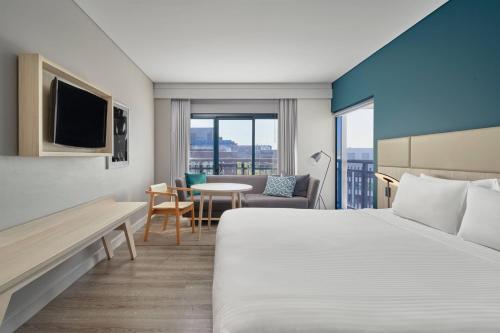 a hotel room with a bed and a table at Courtyard by Marriott Sydney-North Ryde in Sydney