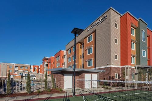 a building with a tennis court in front of it at Residence Inn Sacramento Davis in Davis