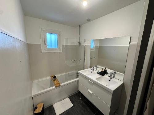 a white bathroom with a sink and a mirror at Le charmeur des dames proche Loire à vélo in La Ville-aux-Dames