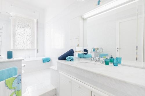 a white bathroom with a sink and a mirror at Stellamaris, Stile Marino e Relax a Viareggio in Viareggio