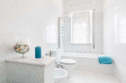 a white bathroom with a toilet and a bath tub at Stellamaris, Stile Marino e Relax a Viareggio in Viareggio