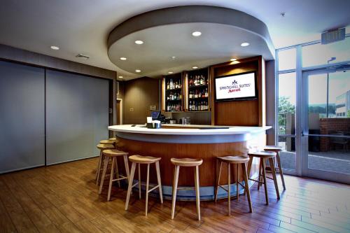 a bar in a restaurant with stools around it at SpringHill Suites Harrisburg Hershey in Harrisburg