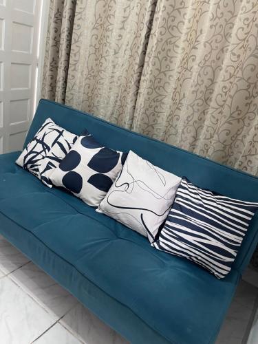 Un sofá azul con tres almohadas. en Casa em praia grande en Praia Grande