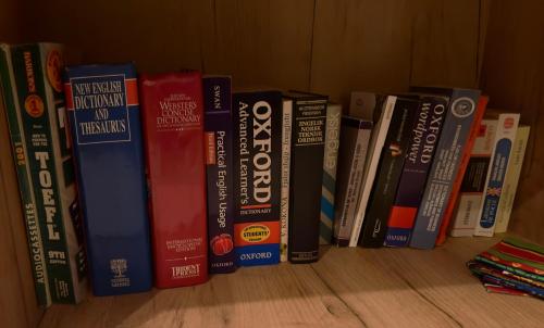 a row of books sitting on a shelf at Elegant Apartment in City Centre in Pristina