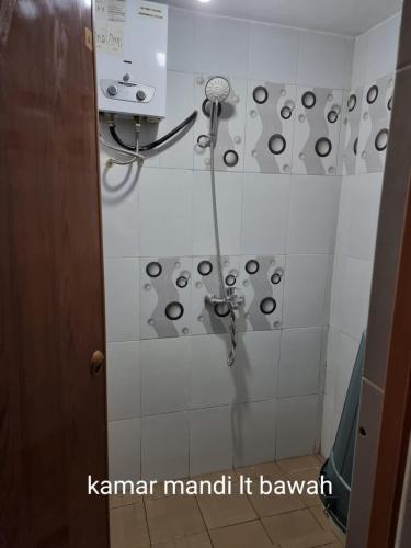 a shower in a bathroom with a shower head at Villa Brastagi Gunung Mas Blok A1 in Berastagi