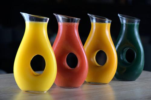 four different colored vases sitting on a table at AC Hotel Som by Marriott in Hospitalet de Llobregat