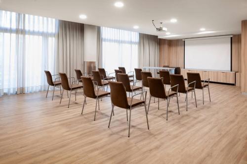 a conference room with chairs and a white screen at AC Hotel Som by Marriott in Hospitalet de Llobregat
