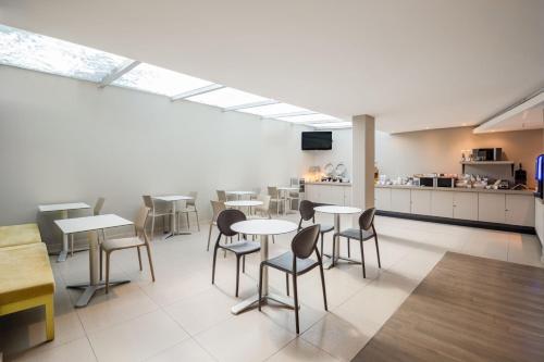 a dining room with tables and chairs and a kitchen at City Express Suites by Marriott Ciudad de México Anzures in Mexico City