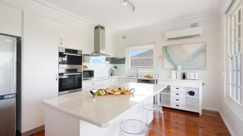 a kitchen with white counters and a white counter top at Adelong in Kiama Downs