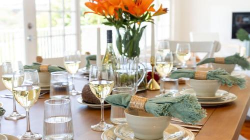 a wooden table with plates and glasses of wine at Adelong in Kiama Downs
