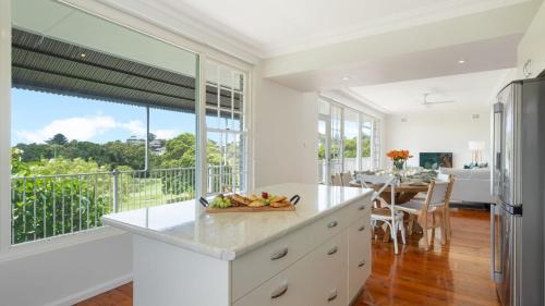 a kitchen with white counters and a large window at Adelong in Kiama Downs