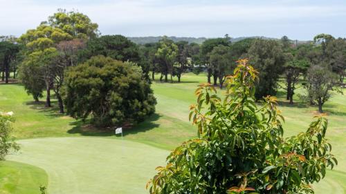 a view of a golf course with trees and a green at Adelong in Kiama Downs