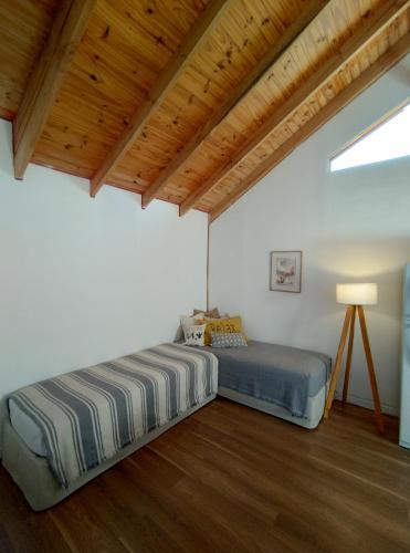 - une chambre avec un lit et un plafond en bois dans l'établissement Playa Serena, à San Carlos de Bariloche