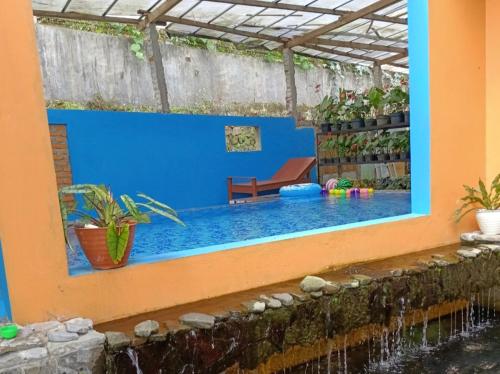 una piscina en medio de una casa en Villa RIJA By Nginep Villa en Tawangmangu