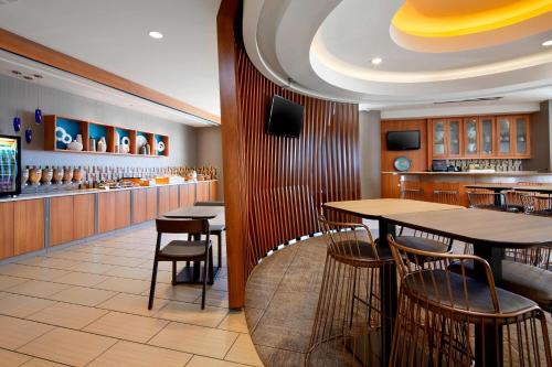 a restaurant with tables and chairs and a bar at SpringHill Suites by Marriott Pittsburgh Bakery Square in Pittsburgh