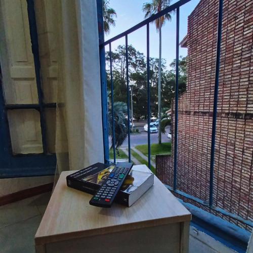 un mando a distancia sentado en una mesa junto a una ventana en Rambla Atlantida Villagio, en Atlántida