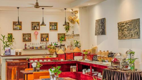 a restaurant with a red counter in a room at Boutique Indochine d'Angkor in Siem Reap