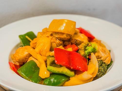 a white bowl of food with peppers and vegetables at Boutique Indochine d'Angkor in Siem Reap