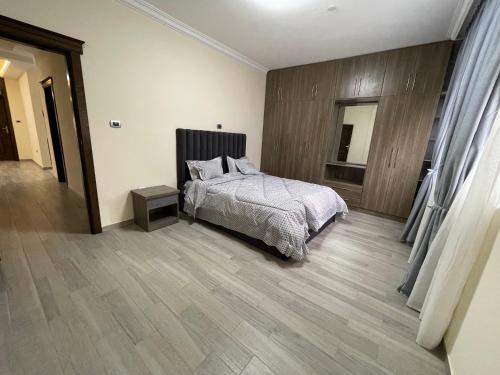 1 dormitorio con 1 cama y suelo de madera en The Hub, en Addis Ababa