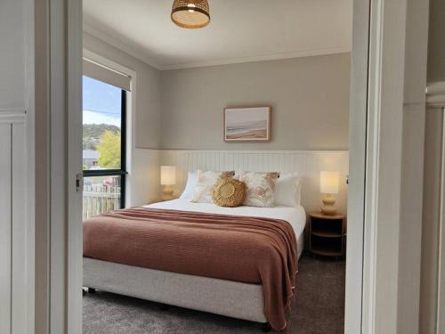ein Schlafzimmer mit einem großen Bett und einem Balkon in der Unterkunft Unit 3 Little Banksia - A Perfect Base in Bicheno