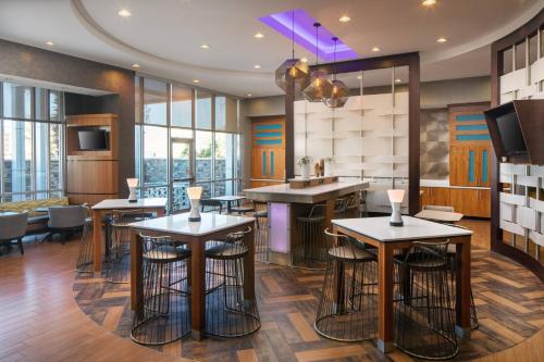 a restaurant with stools and tables in a room with windows at SpringHill Suites by Marriott Midland Odessa in Midland