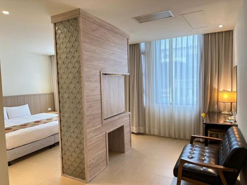 um quarto de hotel com uma cama e uma lareira em East Town 26 Hotel em Hualien City