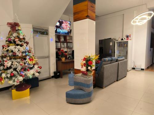 HOTEL VIP 46 SSQS في Bagua Grande: غرفة معيشة مع شجرة عيد الميلاد وأريكة