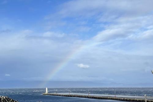 a bridge over the ocean with a blue sky at 三浜館 伊豆大島 in Oshima