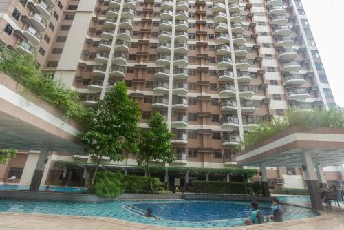 a large apartment building with a swimming pool in front of it at The Radiance Manila Bay Condo unit in Manila