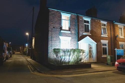 a brick building with a white door on a street at night at Town Centre House with parking, Wi-Fi in Stafford