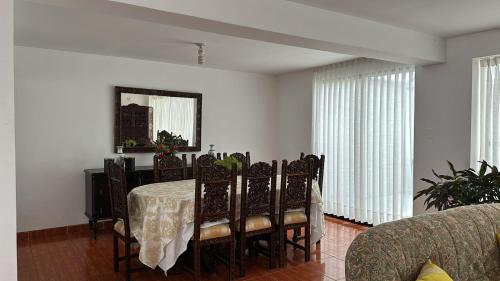a dining room with a table with chairs and a mirror at Habitación cerca a los Pantanos de Villa in Lima