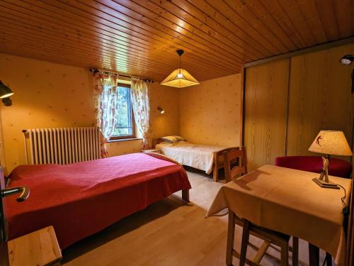 een slaapkamer met 2 bedden en een tafel met een lamp bij Gîte La Bresse, 3 pièces, 5 personnes - FR-1-589-152 in La Bresse