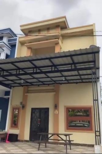 awning over a picnic table in front of a house at VILLA BRASTAGI SINABUNG VIEW in Berastagi