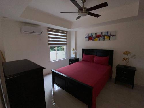 a bedroom with a red bed and a ceiling fan at The Echelon Suite in Kingston