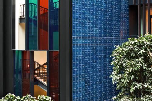 un edificio alto de color azul con ventanas de cristal reflectante en Dorothea Hotel, Budapest, Autograph Collection, en Budapest