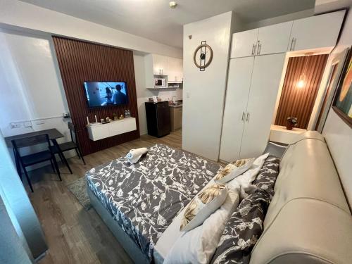 a bedroom with a bed and a tv in it at Mesavirre Garden Residence in Bacolod