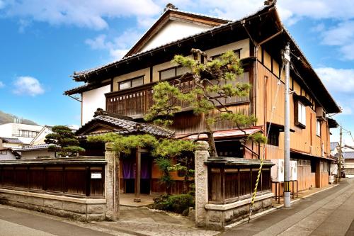 a building with a tree on the side of it at Hideaway Tabaki in Echizen-shi