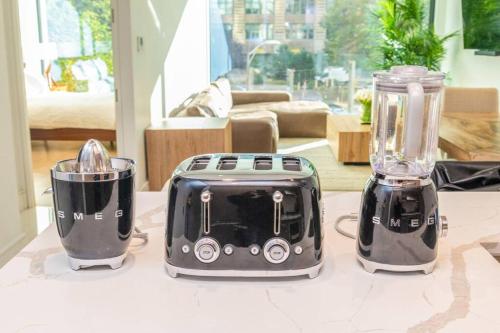 three toasters sitting on a table in a living room at Luxurious Soho Apartment~ 2 Bedroom 2 Bathroom in New York