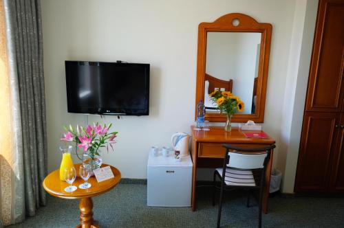a room with a desk and a mirror and a table at City Inn Palace Hotel in Ramallah