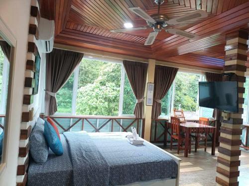 a bedroom with a bed and a flat screen tv at Mountain View Guest House in Phatthalung