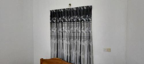 a curtain on a window in a room at Shiven Homestay in Kallady