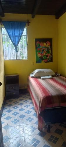 1 dormitorio con 1 cama en una habitación con ventana en Hotel y Restaurante Playa Linda en San Pedro La Laguna