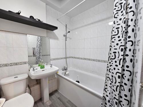 a bathroom with a sink and a toilet and a bath tub at Spitalfields Rooms in London